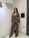 Tailleur gessato Amelie nella variante marrone cioccolato, composto da blazer con cintura annodata in vita e pantaloni a palazzo con spacco laterale sul fondo.