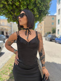 Corpetto Petra bustier in raso nero lucido FAEV, caratterizzato da coppe sagomate e abbinato a occhiali da sole scuri e choker al collo.