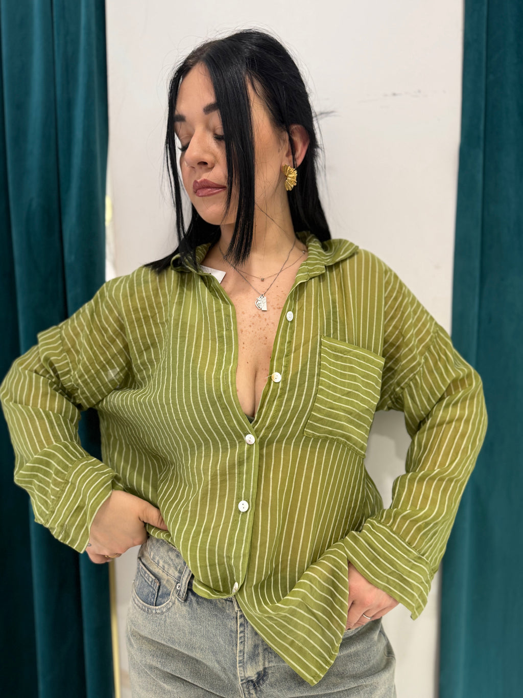 Camicia Positano verde a righe verticali semitrasparente FAEV, indossata aperta con top giallo e shorts di jeans a vita alta.