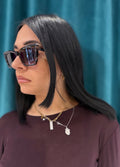 Dettaglio laterale degli Occhiali Shade con montatura spessa squadrata e tartarugata scura, lenti da sole sfumate e angoli stile cat-eye.