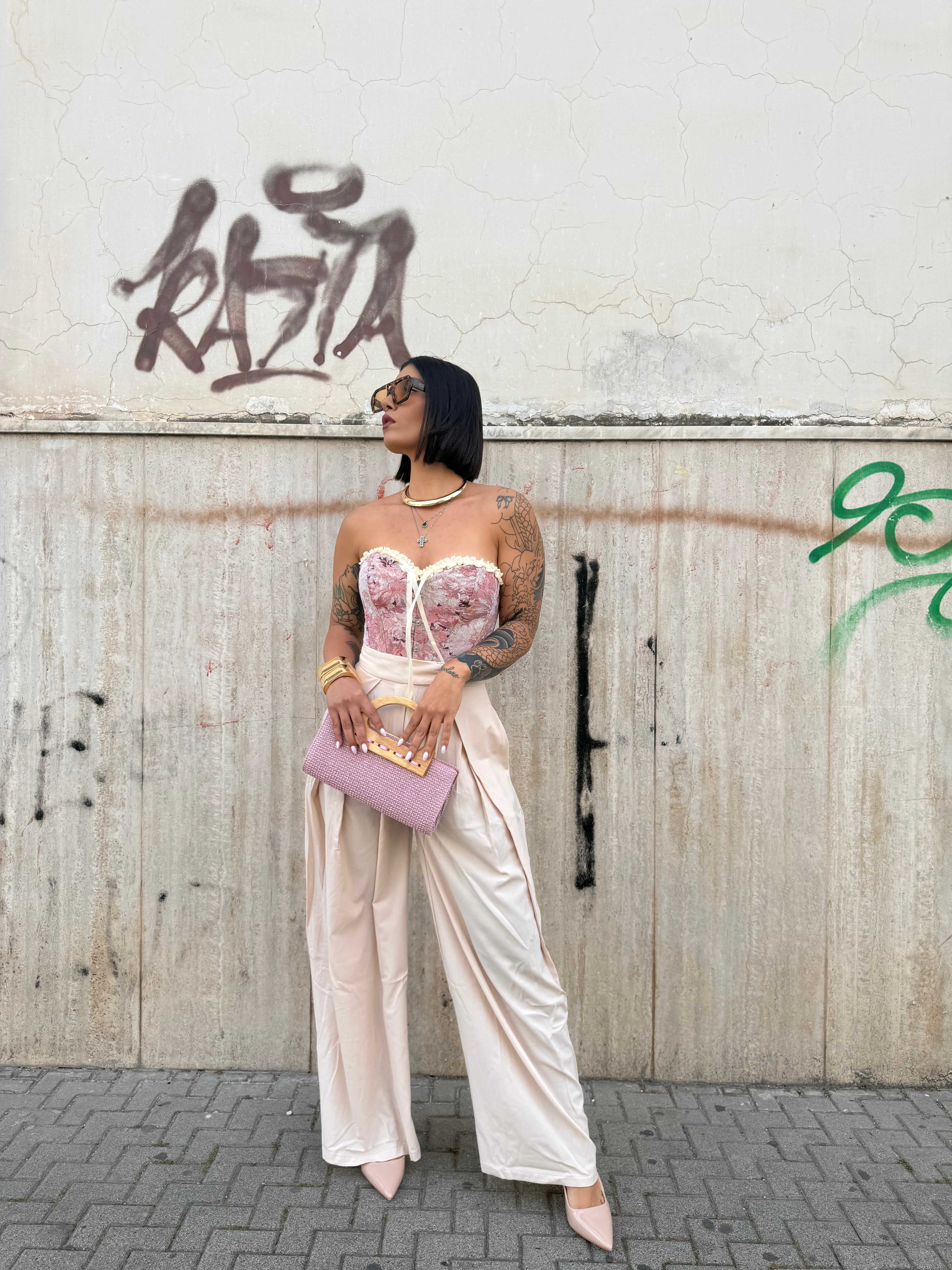 Pantalone Millenium a palazzo a vita alta color beige con pence frontali e linea pulita FAEV, abbinato a top a corsetto rosa e borsa a mano.
