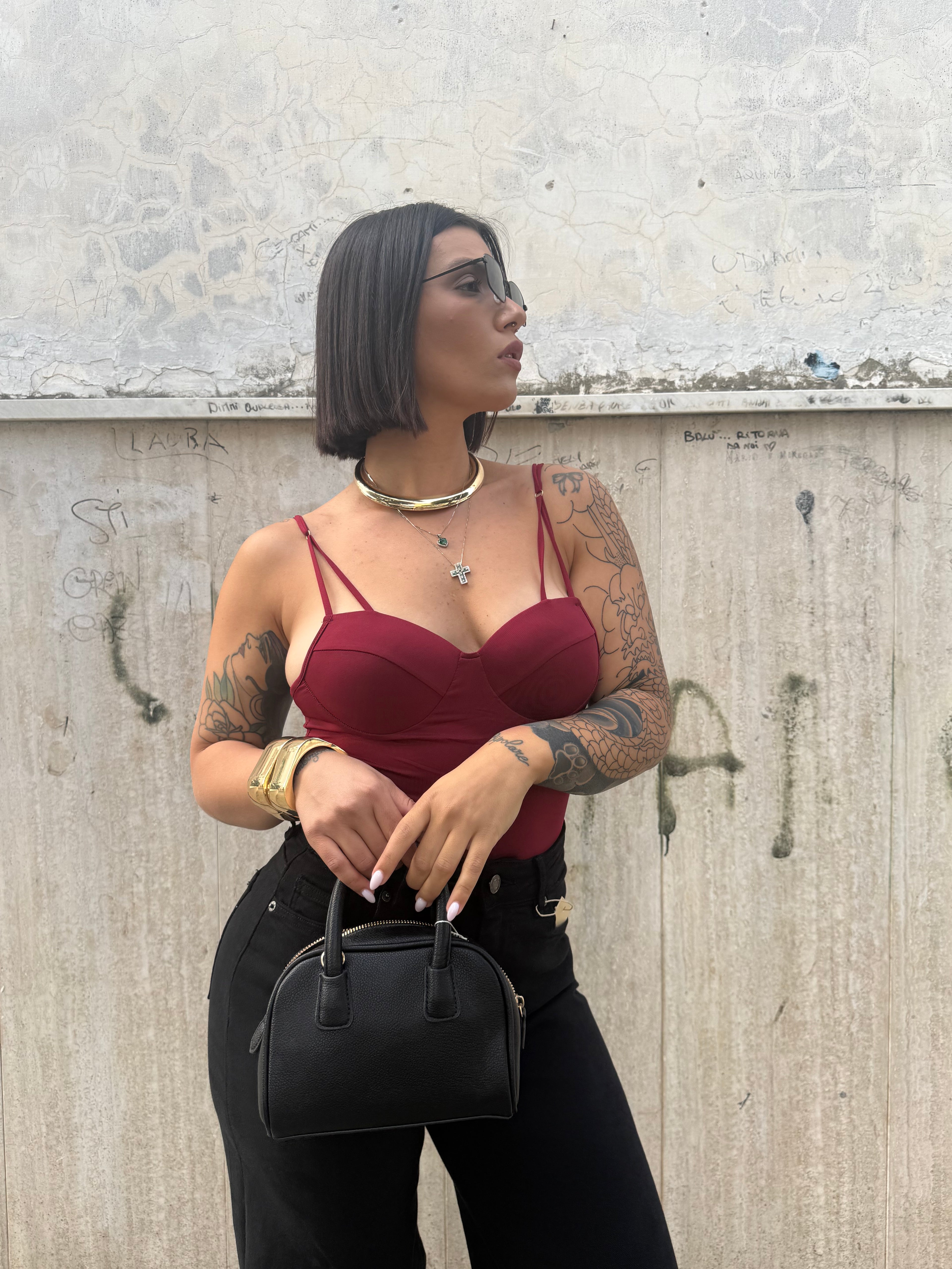 Body Alena in lycra color bordeaux con coppe a balconcino e spalline sdoppiate FAEV, abbinato a jeans neri.