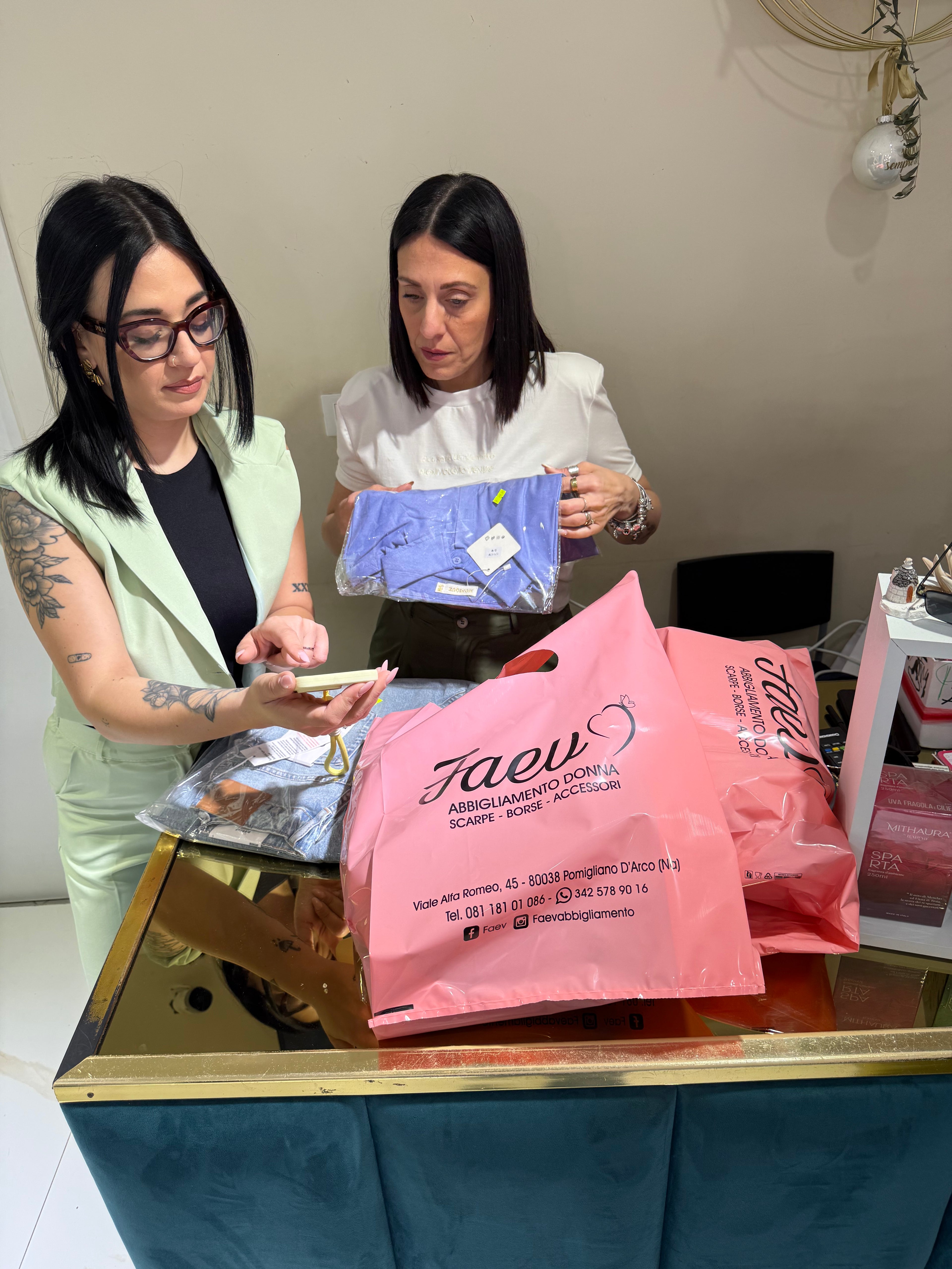 Preparazione degli ordini online sul banco della boutique FAEV a Pomigliano d'Arco con packaging personalizzato per abbigliamento donna.