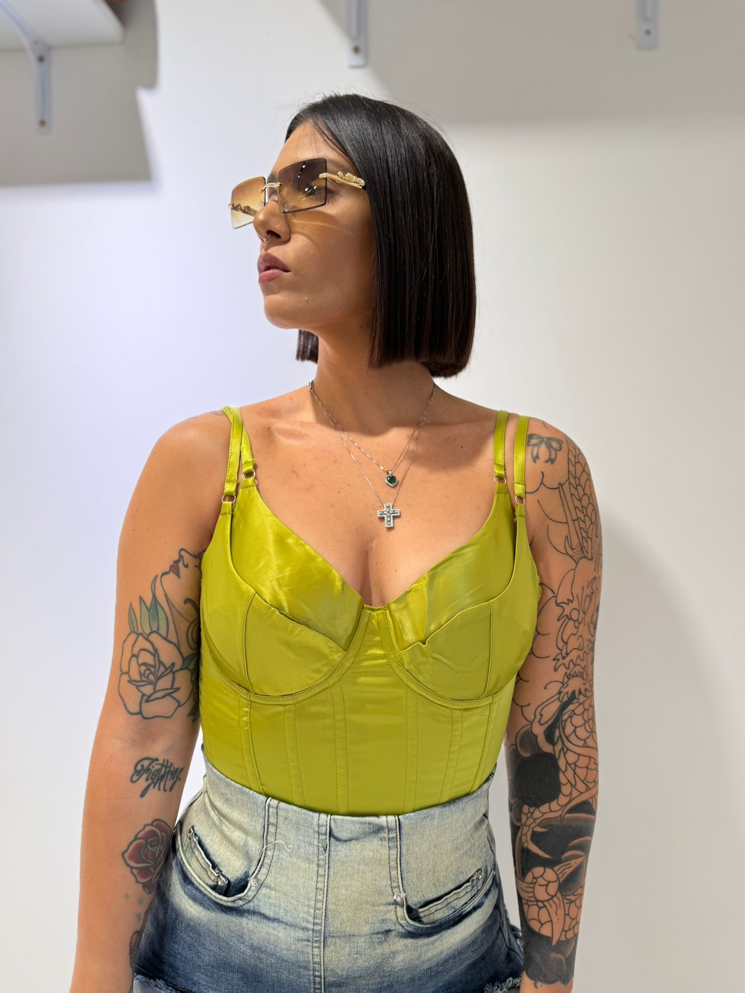 Corpetto Petra bustier in raso lucido verde acido con scollo a cuore e doppie spalline sottili FAEV, abbinato a shorts in jeans.
